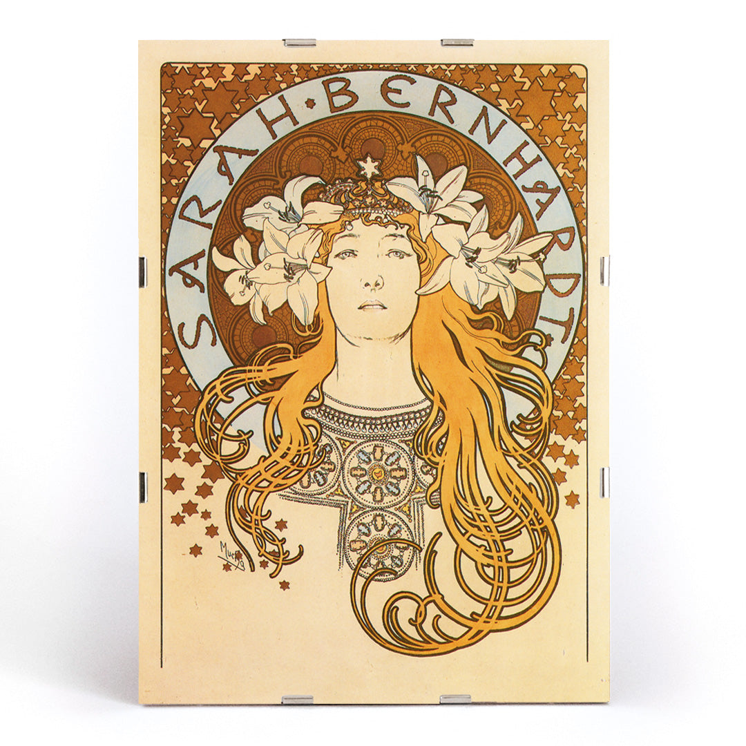 Art Nouveau poster of Sarah Bernhardt with flowing hair floral crown and lilies by Alphonse Mucha from La Plume, framed and displayed in modern living room decor