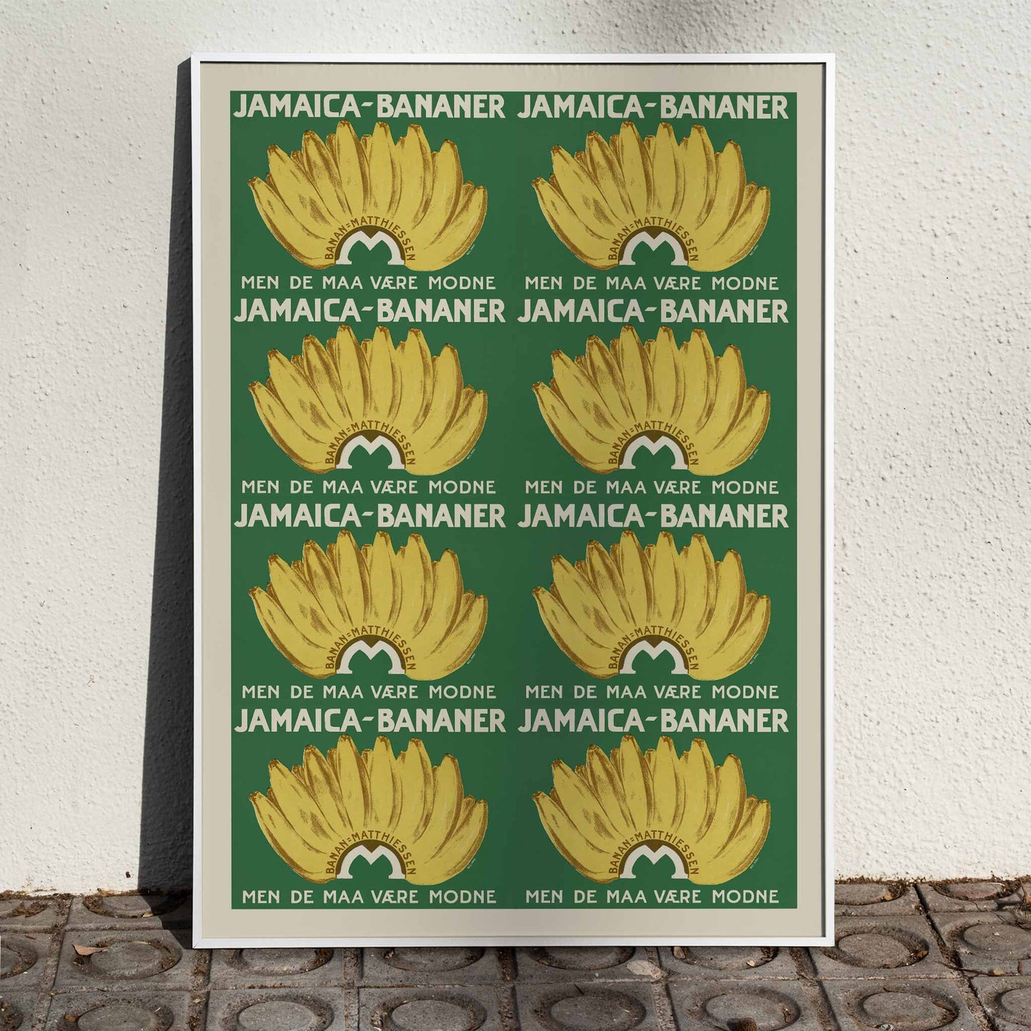 Jamaica Bananas poster with repeated ripe yellow banana bunches on a deep green vintage advertising design, framed and displayed in home decor