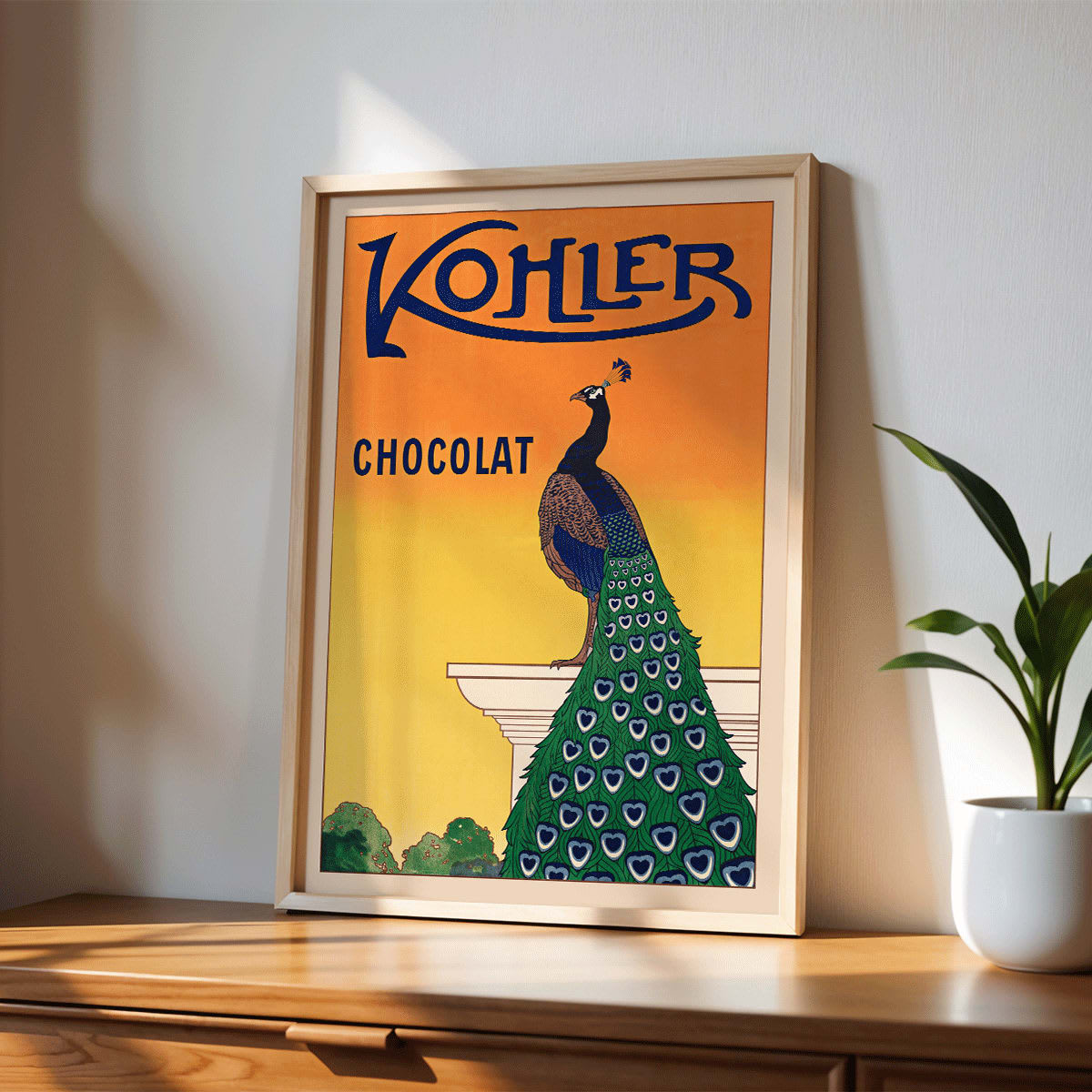 Kohler Chocolat art nouveau poster by F Champenois with vibrant peacock on pedestal against orange background, framed and displayed in home decor