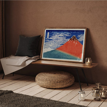 Fine Wind Clear Morning by Katsushika Hokusai poster showing red Mount Fuji under blue sky with white clouds, framed and displayed in home decor