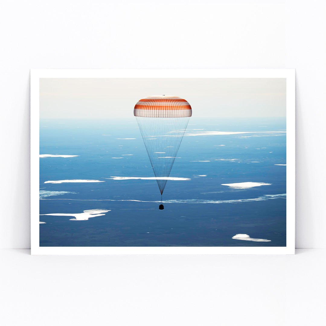 Soyuz MS-02 spacecraft descending with parachute over Kazakhstan NASA poster artwork showing landing, framed and displayed in modern living room decor