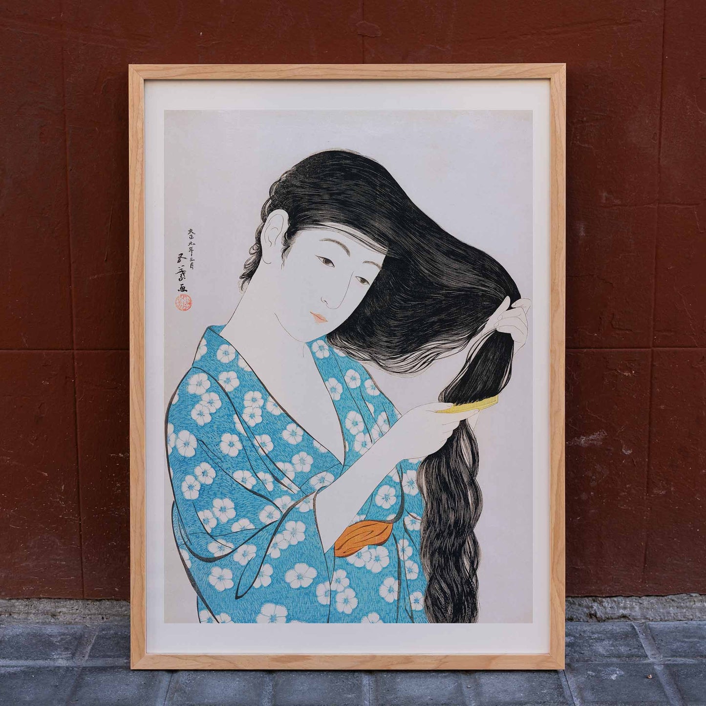 Woman in blue floral kimono combing her long hair artwork Woman Combing Her Hair by Goyo Hashiguchi Japanese art poster, framed and displayed in home decor