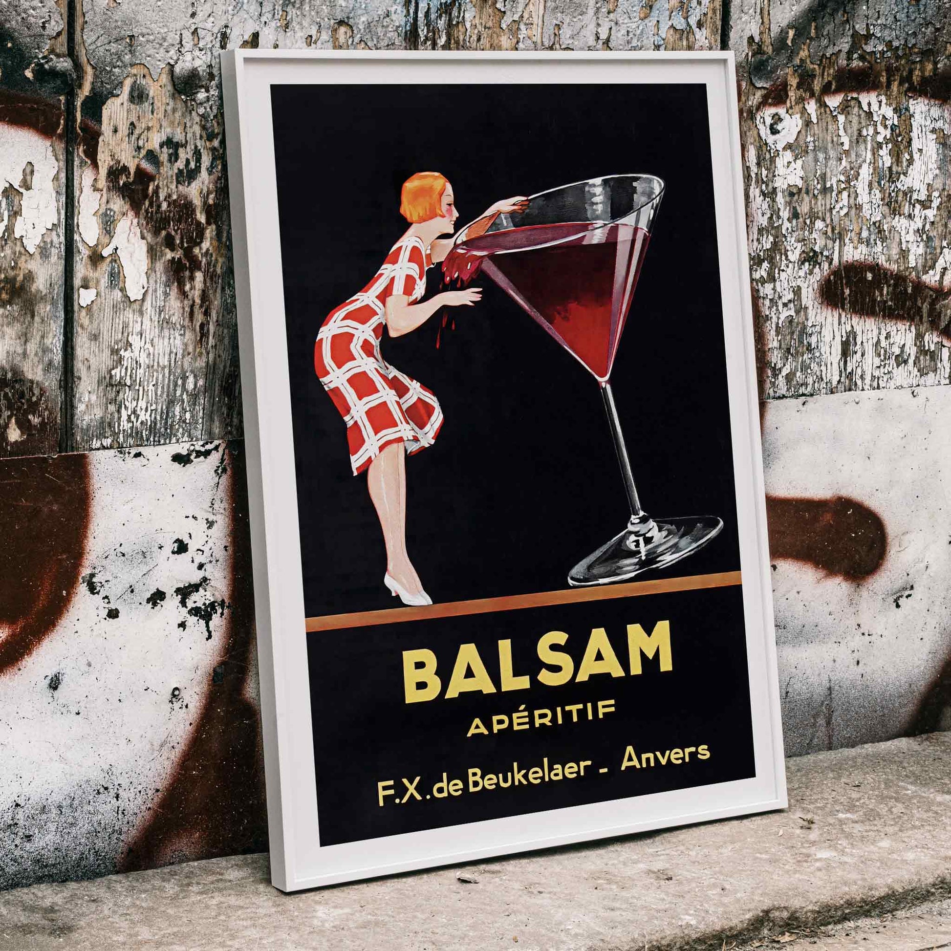 Balsam Aperitif poster by Jean d Ylen showing a woman sipping from a giant red cocktail glass vibrant vintage art, framed and displayed in home decor