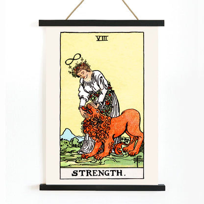 Tarot Strength card by Rider Waite showing a woman calming a lion with an infinity symbol above her head, with wooden magnetic frame on white background