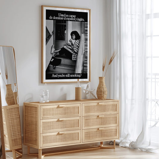 Young woman reading and smoking on stairs in bilingual anti-smoking poster by US Department of Health and Human Services titled Usted es capaz de dominar el español y inglés and you are still smoking, framed and displayed in home decor